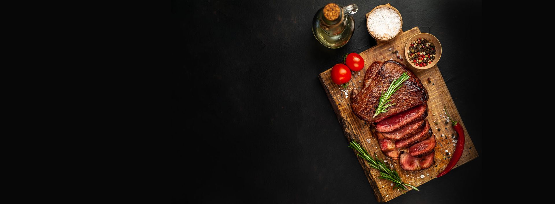 Steak auf einem Holzbrett mit Gewürzen